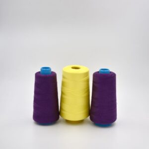 Three spools of thread, two purple and one yellow.