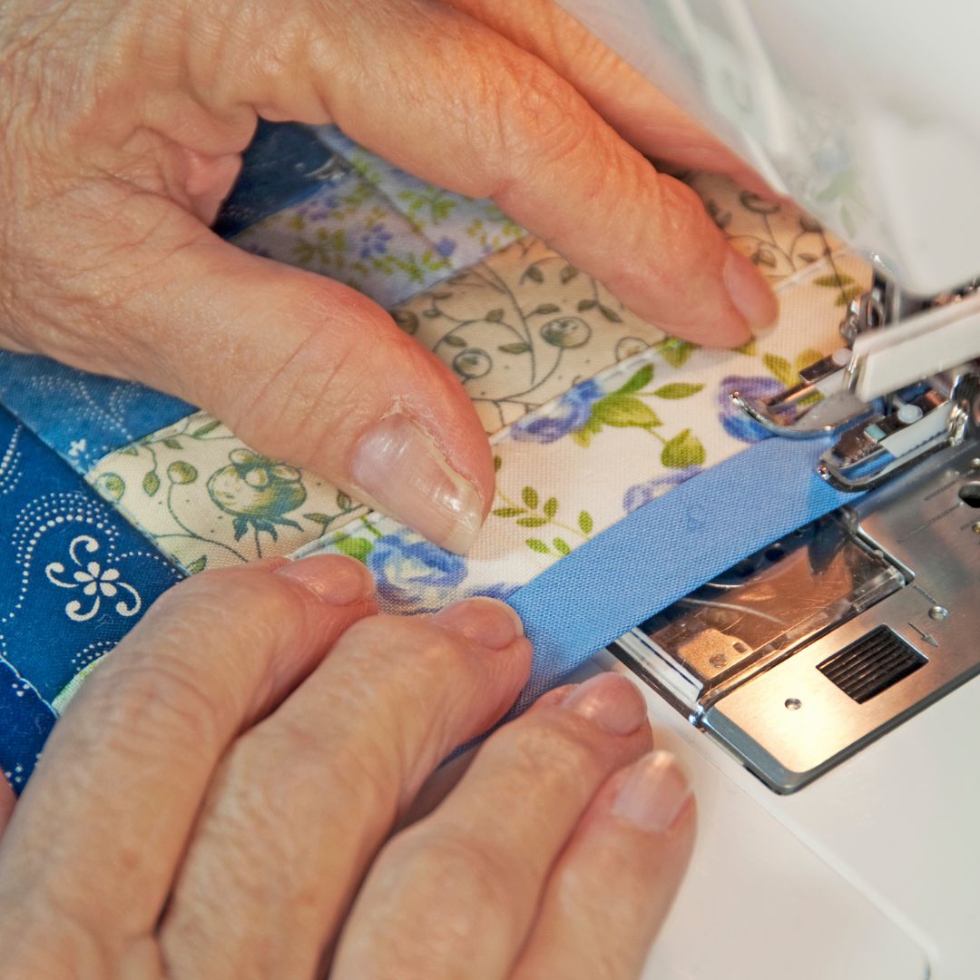 someone sewing a seam on a quilt