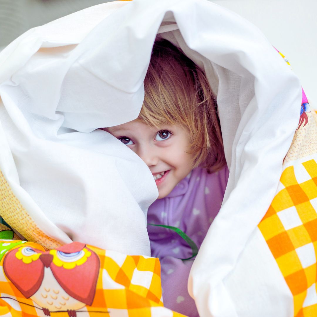 little girl wrapped up in a quilt