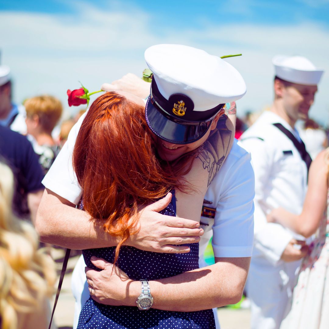 Navy personnel hugging spouse