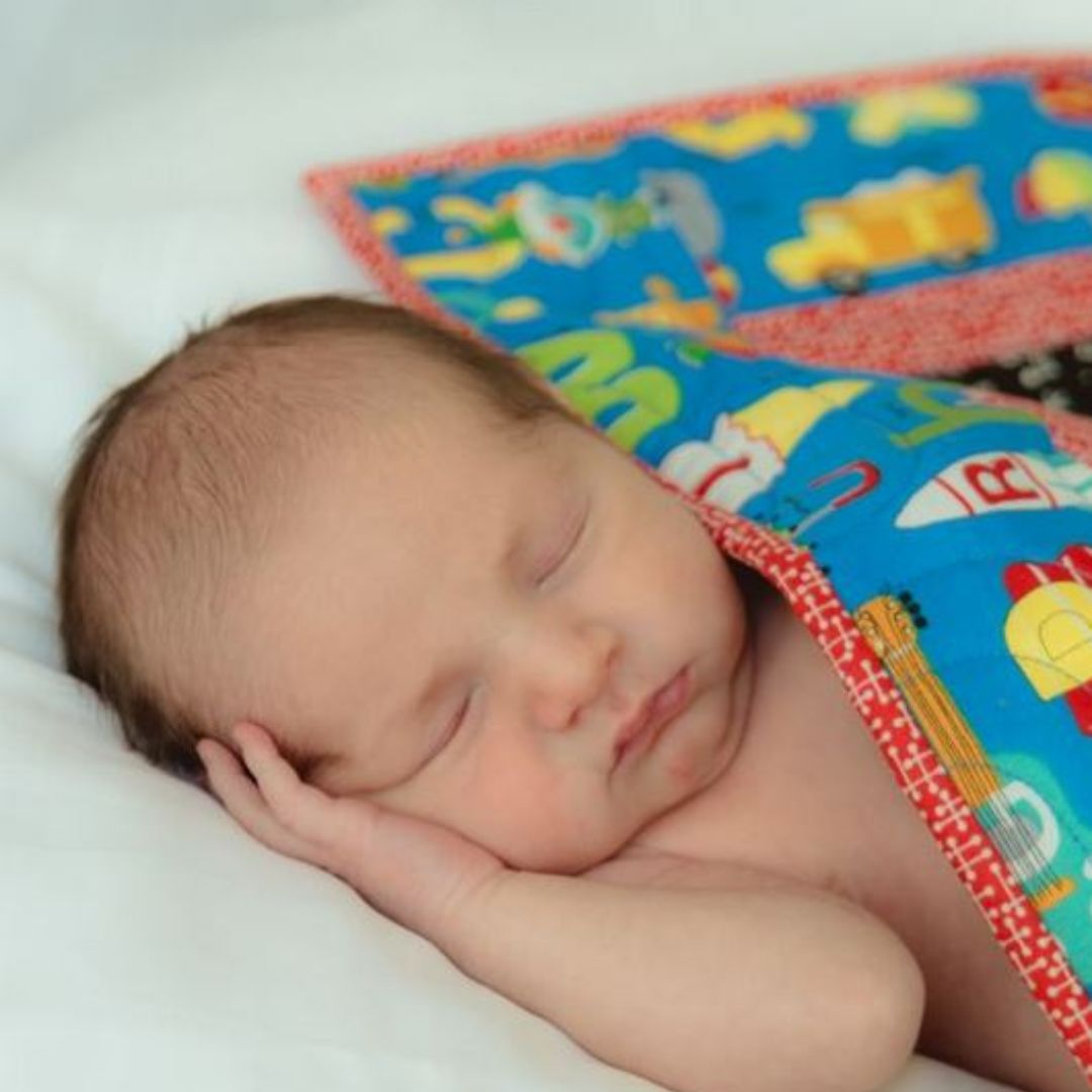 baby sleeping with a quilt
