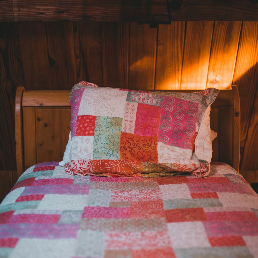 pink quilted comforter and pillow on bed